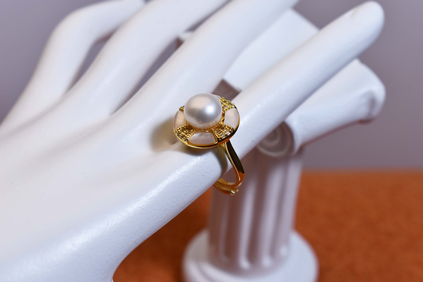 Natural pearl ring with white circular abalone shell surrounding the opening, adjustable ring