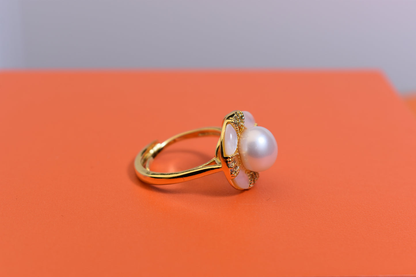 Natural pearl ring with white circular abalone shell surrounding the opening, adjustable ring