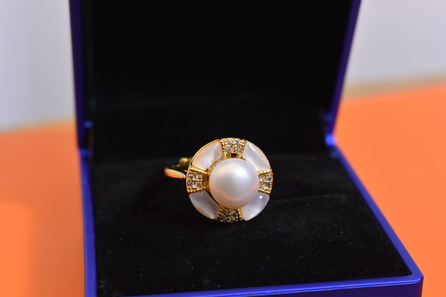 Natural pearl ring with white circular abalone shell surrounding the opening, adjustable ring