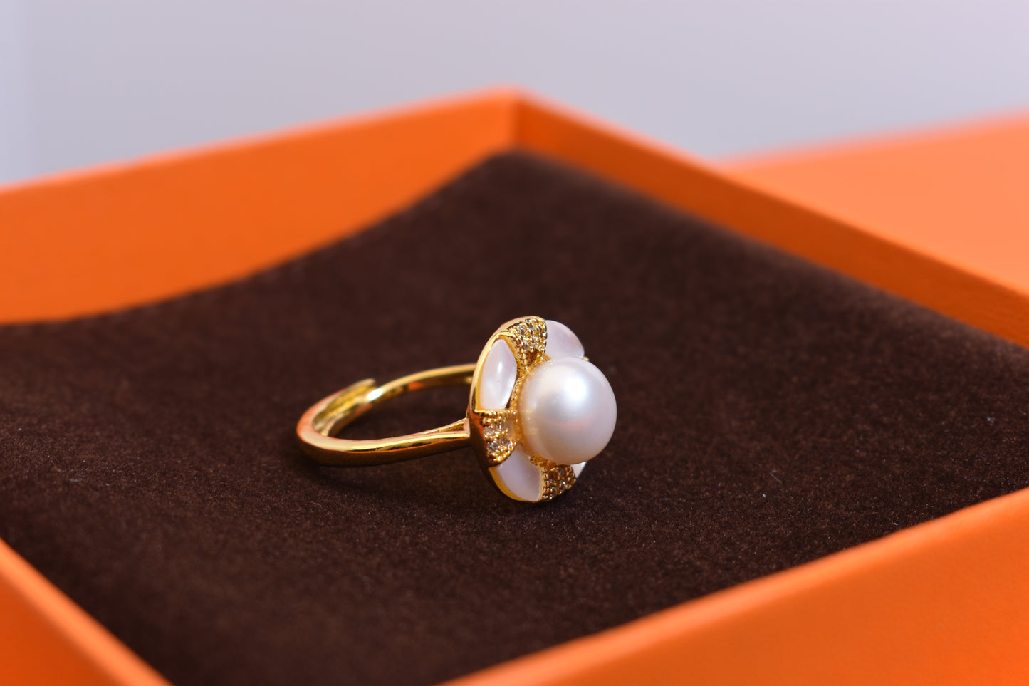 Natural pearl ring with white circular abalone shell surrounding the opening, adjustable ring