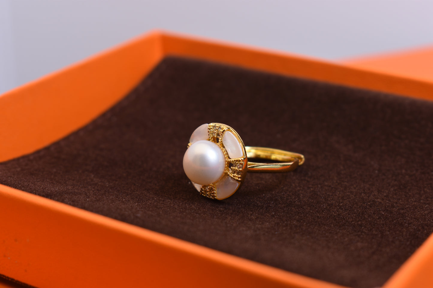 Natural pearl ring with white circular abalone shell surrounding the opening, adjustable ring