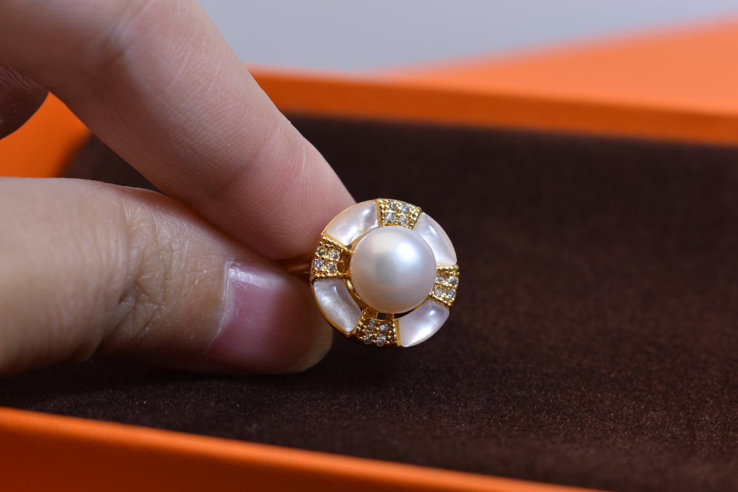 Natural pearl ring with white circular abalone shell surrounding the opening, adjustable ring