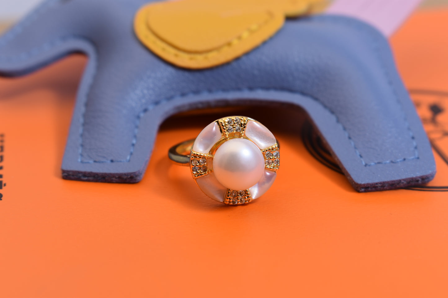 Natural pearl ring with white circular abalone shell surrounding the opening, adjustable ring