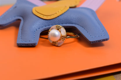 Natural pearl ring with white circular abalone shell surrounding the opening, adjustable ring