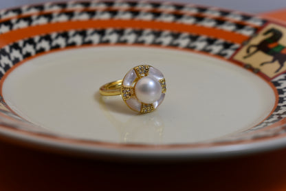 Natural pearl ring with white circular abalone shell surrounding the opening, adjustable ring